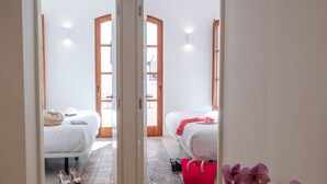 A hallway leading to two bedrooms with a wooden floor, a red bag, and a purple orchid. - New duplex in Ibiza center with Dalt Vila views (Ibiza)