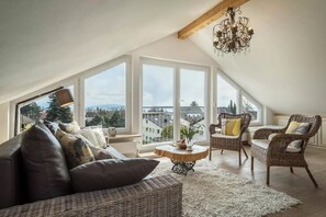 Um amplo quarto no estilo loft, com grandes janelas, teto alto e lustre.
