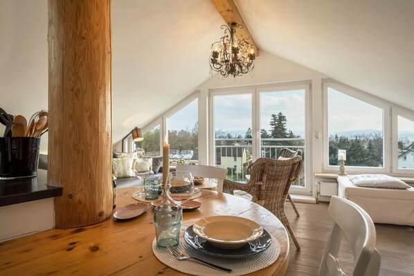 Enjoy meals in a spacious dining area with a scenic view, a wooden dining table, and comfortable seating.