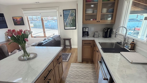 Una cocina moderna con armarios de madera, encimera de mármol y alfombra estampada.