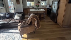 Una cocina moderna con armarios de madera, un refrigerador y un comedor con mesa y sillas.