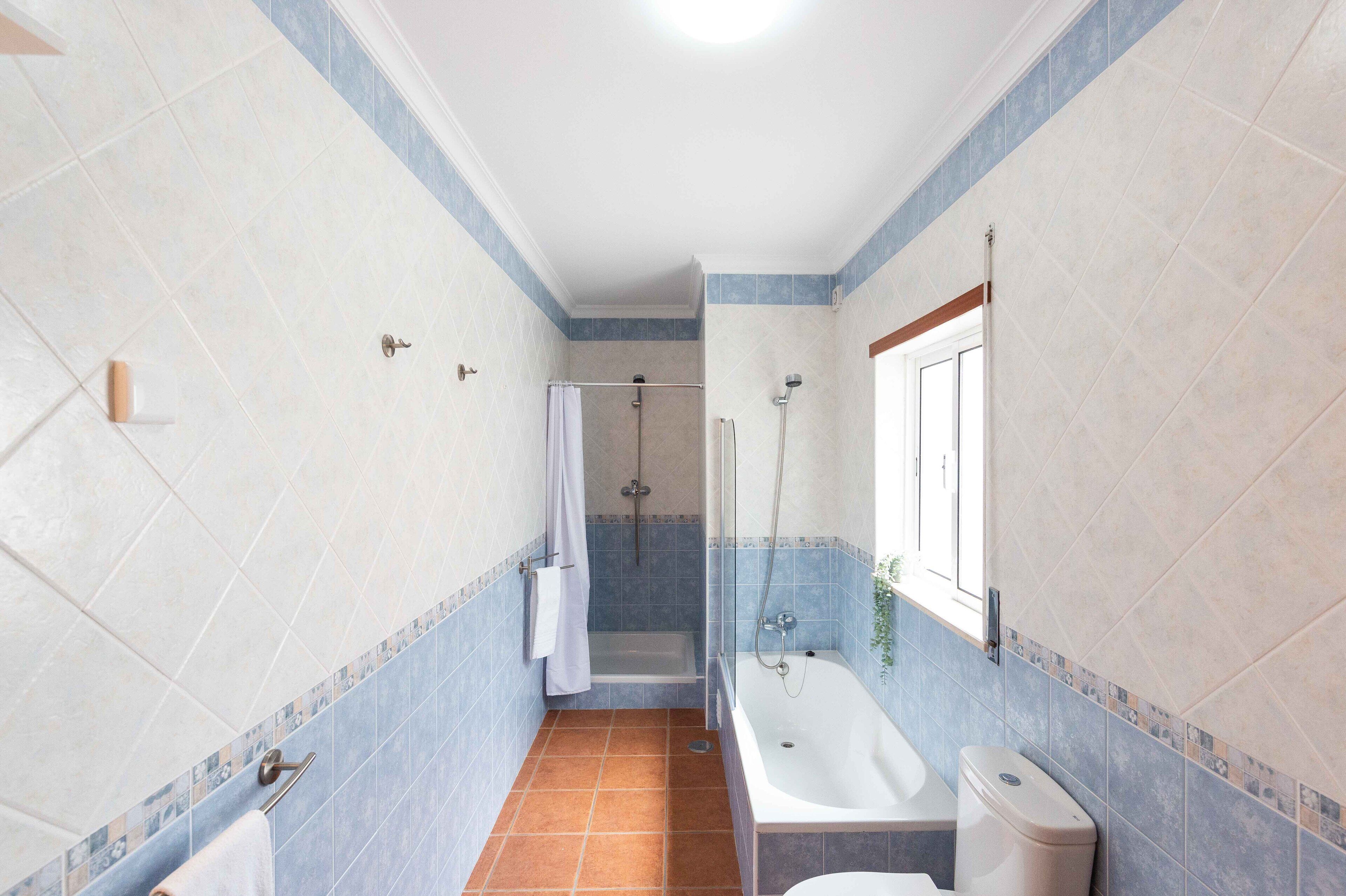 A bathroom with a shower, toilet, and bathtub.