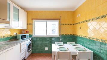 Apartamento premium, 2 quartos | Cozinha privada | Geladeira, micro-ondas, cooktop, lava-louças