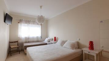 Habitación de hotel con dos camas, un televisor, un escritorio y una silla.