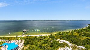 Ein Küstenhotel mit Schwimmbad, Strand und Steg.