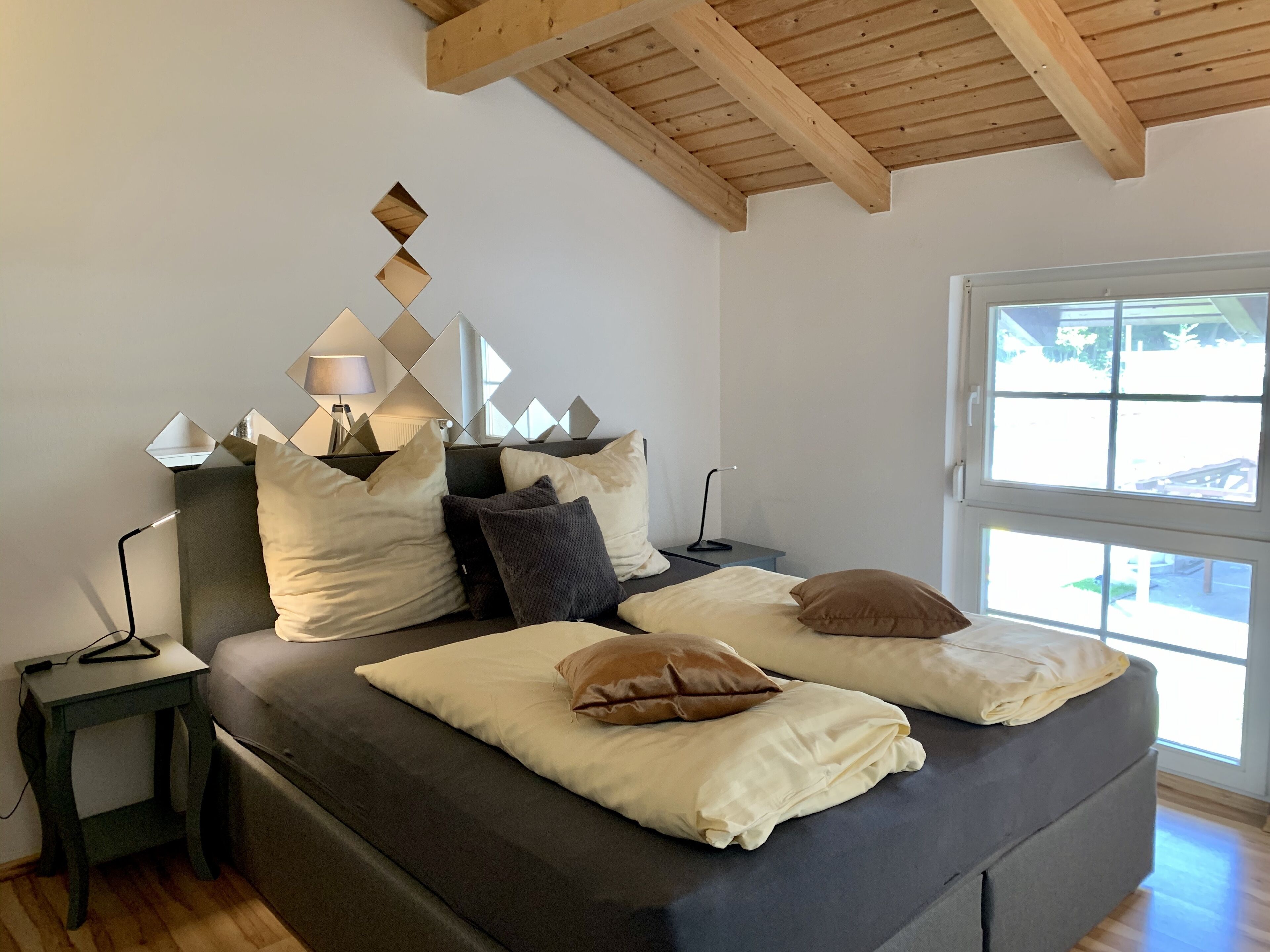 Ein modernes Schlafzimmer mit einem Bett, Nachttischen und einem Fenster.