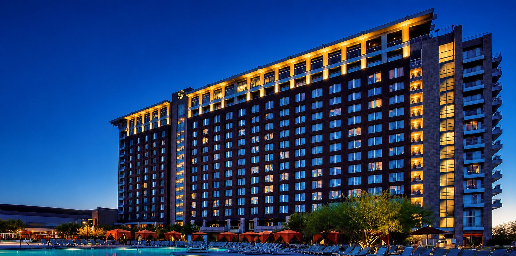 A multi-story hotel with a pool area in the foreground.