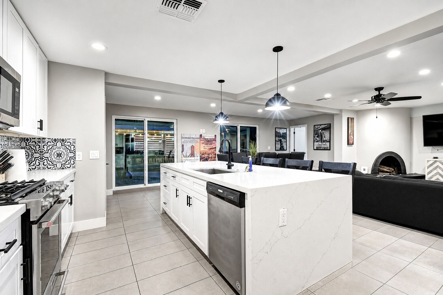 A modern kitchen with a central island, built-in appliances, and a dining area with a fireplace.