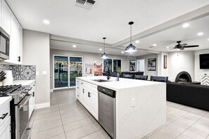 A modern kitchen with a central island, built-in appliances, and a dining area with a fireplace.