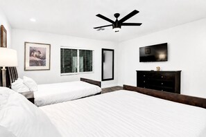A hotel room with two beds, a ceiling fan, a TV, a dresser, and a window with blinds. - ScottsdaleStays 9BR-6BA Multimillion Estate-Huge Yard-Pickleball-The Best Area. (Scottsdale)
