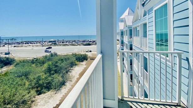 Un balcon donnant sur un parking et une plage.