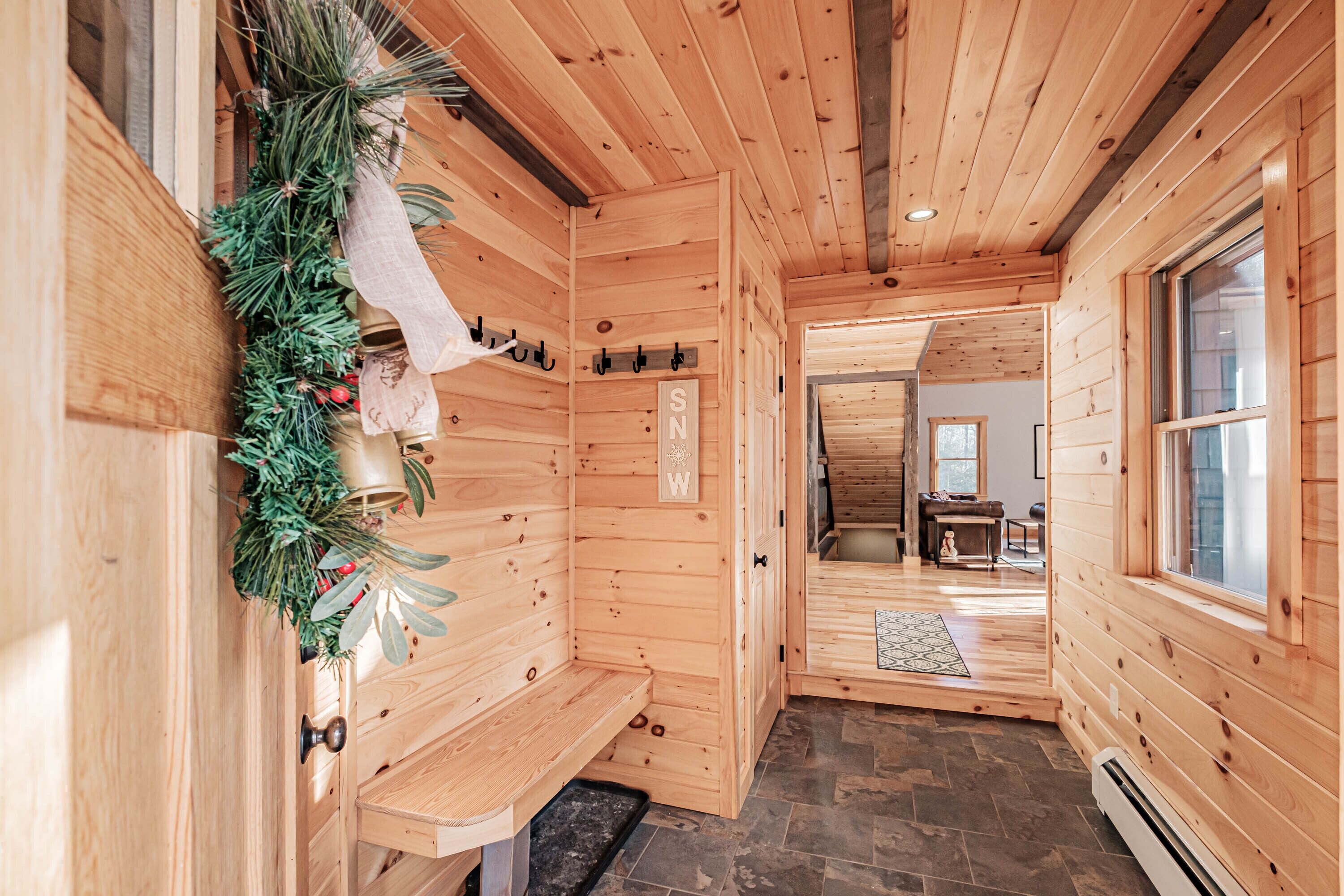 A wooden cabin interior with a sauna, a bench, and a Christmas wreath.