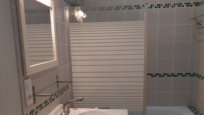A bathroom with a white sink, mirror, and bathtub. - Quiet gite - 20 mn from Royan, 10mn from Saintes (Retaud)