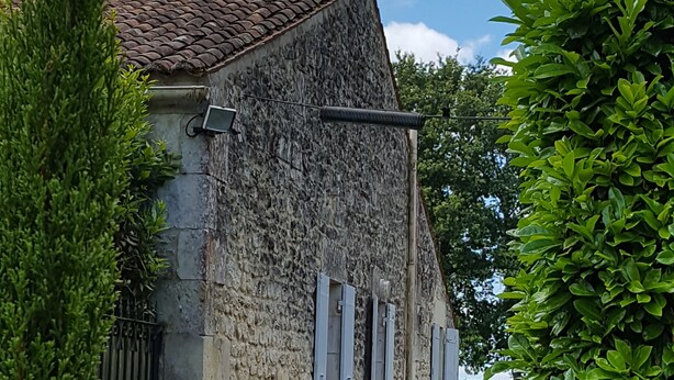A stone building with a tiled roof, a narrow pathway, and lush greenery. - Quiet gite - 20 mn from Royan, 10mn from Saintes (Retaud)