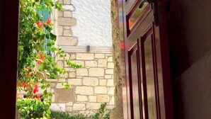 An arched doorway leading to a stone building with a lantern above. - Afet Inn Hotel (Cesme)