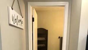 A hallway with a 'Welcome' sign, a dark closet, and a light wooden floor. - "The Sweet Suite" - Private & Quiet, Near 408/417 (Orlando)