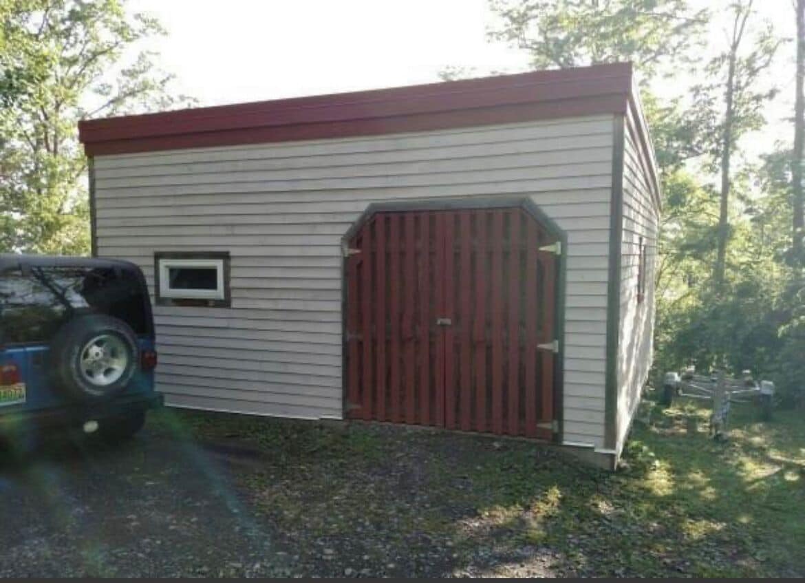 Un petit bâtiment d’un seul étage, avec une porte rouge et une petite fenêtre.