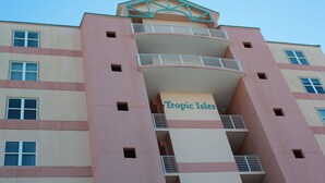 Un hôtel à plusieurs étages, doté de balcons et d’une enseigne indiquant « Tropic Isles ».
