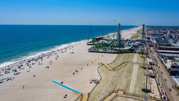 An aerial view of a beach with a roller coaster, a boardwalk, and a sandy shore. - Hammock Inn & Suites - Jersey Shore (Seaside Heights)