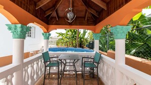 A covered outdoor area with a pool, wooden ceiling, and green chairs. - Runaway Bay Gem, Spacious and Bright, 5 mins drive to the Beach! (Runaway Bay)