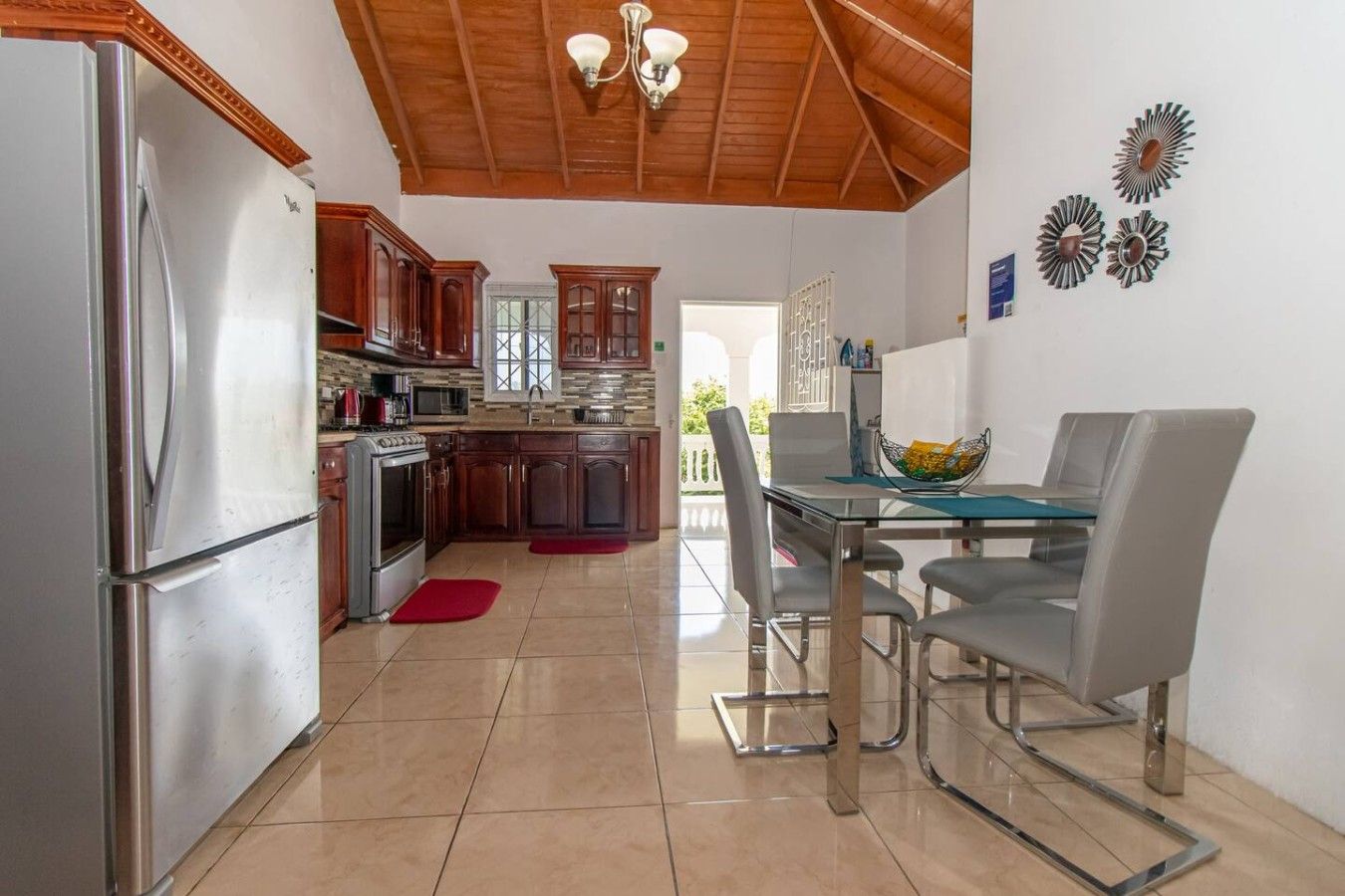 Une cuisine équipée d’un réfrigérateur, d’une cuisinière et d’une table à manger avec des chaises.