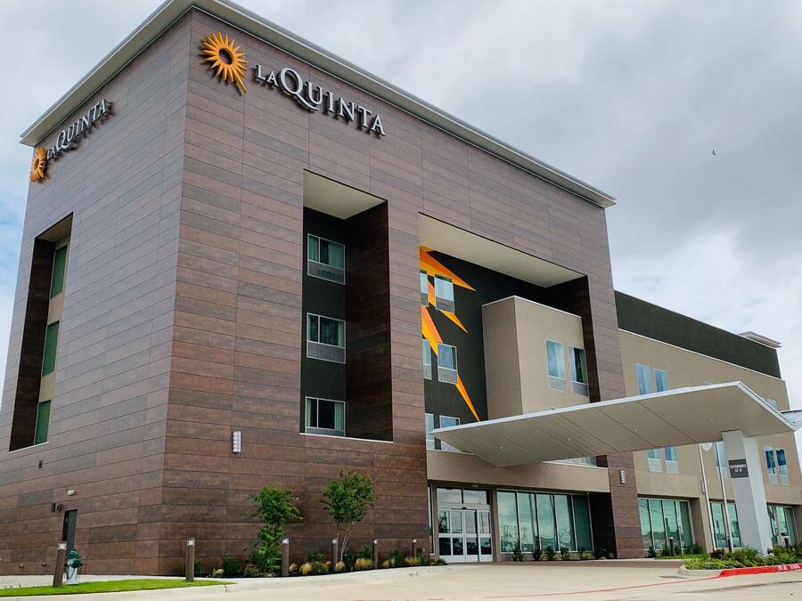 Ett modernt hotell med en tydlig skylt med texten ”La Quinta”, stora fönster och en ingång som är skyddad av ett tak.
