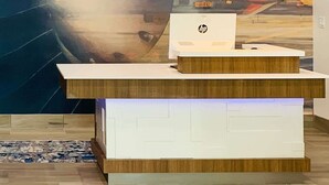 Un mostrador de recepción con un mural de la ciudad, dos lámparas colgantes y un logotipo de HP en la encimera.