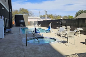 A pool area with a hot tub, lounge chairs, and a small table. - La Quinta Inn & Suites by Wyndham-Red Oak TX IH-35E (Red Oak)