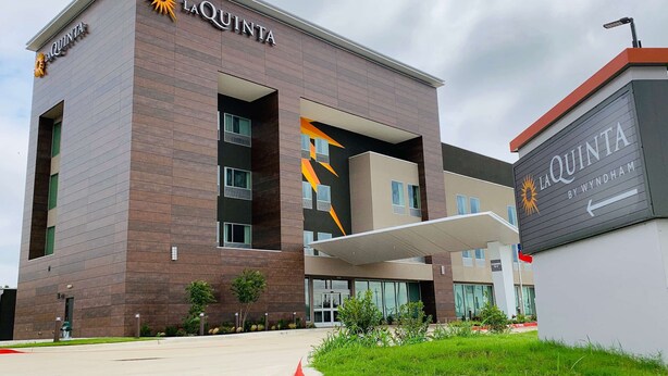 Un edificio de hotel moderno con el nombre 'La Quinta' bien visible en la fachada.