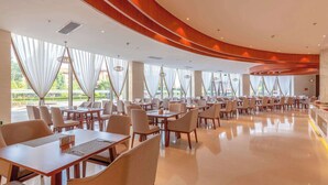 Un restaurant spacieux, doté de hauts plafonds, de grandes fenêtres et d’un design moderne.