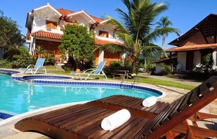 Una piscina al aire libre, sombrillas, sillones reclinables de piscina