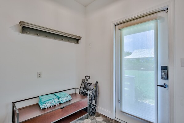 Quarto com um banco, um carrinho de bebê e uma porta com vista para o exterior.
