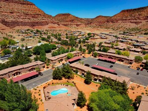 A residential area with houses, a swimming pool, and a mountainous backdrop.