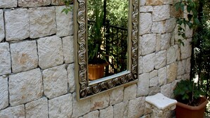 A stone wall with a decorative mirror and two small pedestals. - Sole'n Blu Hotel (Kas)