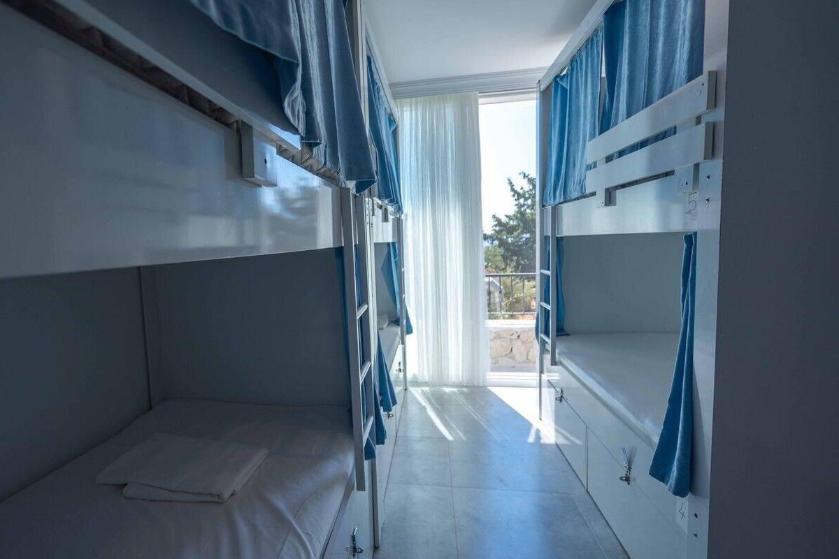 A bunk bed room with a window and curtains.
