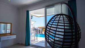 A room with a large sliding glass door leading to a balcony with a pool. - Sole'n Blu Hotel (Kas)