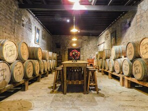 A cellar with wooden barrels labeled 'Torres de Martell' arranged around tables. - Hacienda La Noria Culture Boutique By Rotamundos (Terrenate)