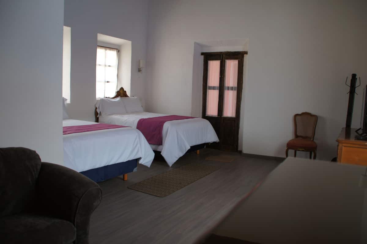 Cubrecamas, espacio para trabajar con laptop y ropa de cama 