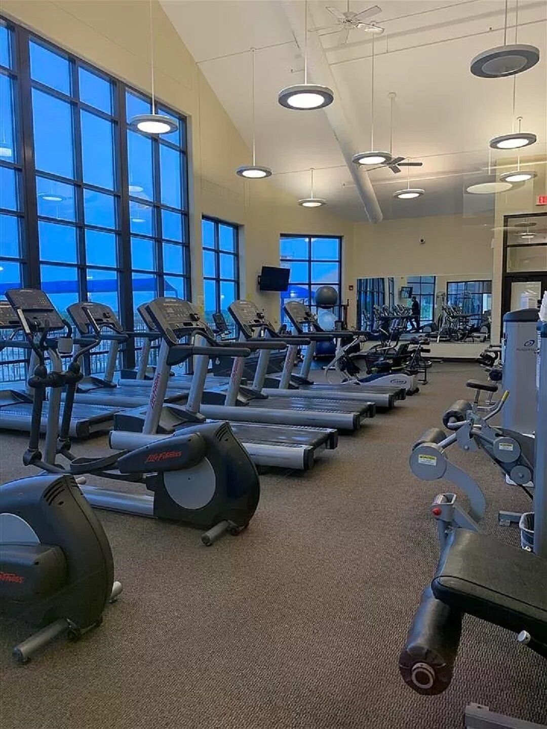A gym with treadmills, stationary bikes, and weight machines.