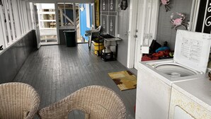 A narrow hallway with wicker chairs, a washing machine, and a trash bin. - Prime spot located on the water, Luxury living Bayou front living at its finest. (Chauvin)