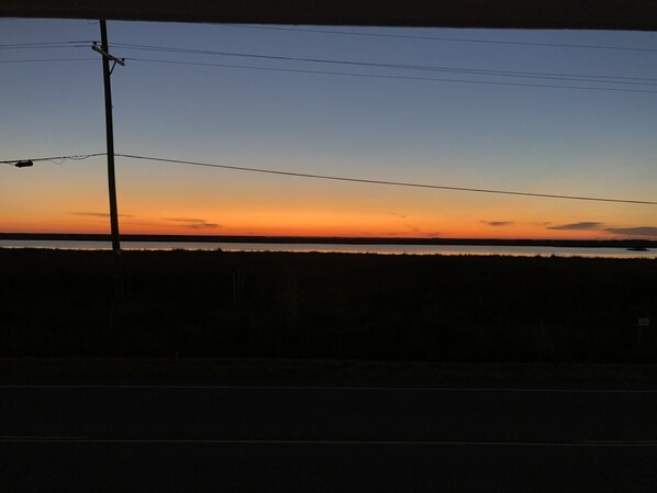 A sunset over a flat landscape with a power line in the foreground.