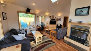 Amplia sala de estar con chimenea, un sofá, un televisor y un comedor.