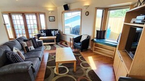 Un salón amplio con un conjunto de sofás, una mesa de centro y un mueble para la televisión.