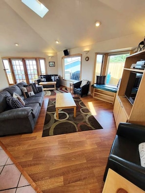 A spacious living room with a sofa set, a coffee table, and a TV stand.