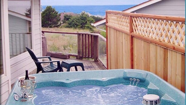 Un jacuzzi en una terraza con vista al océano.