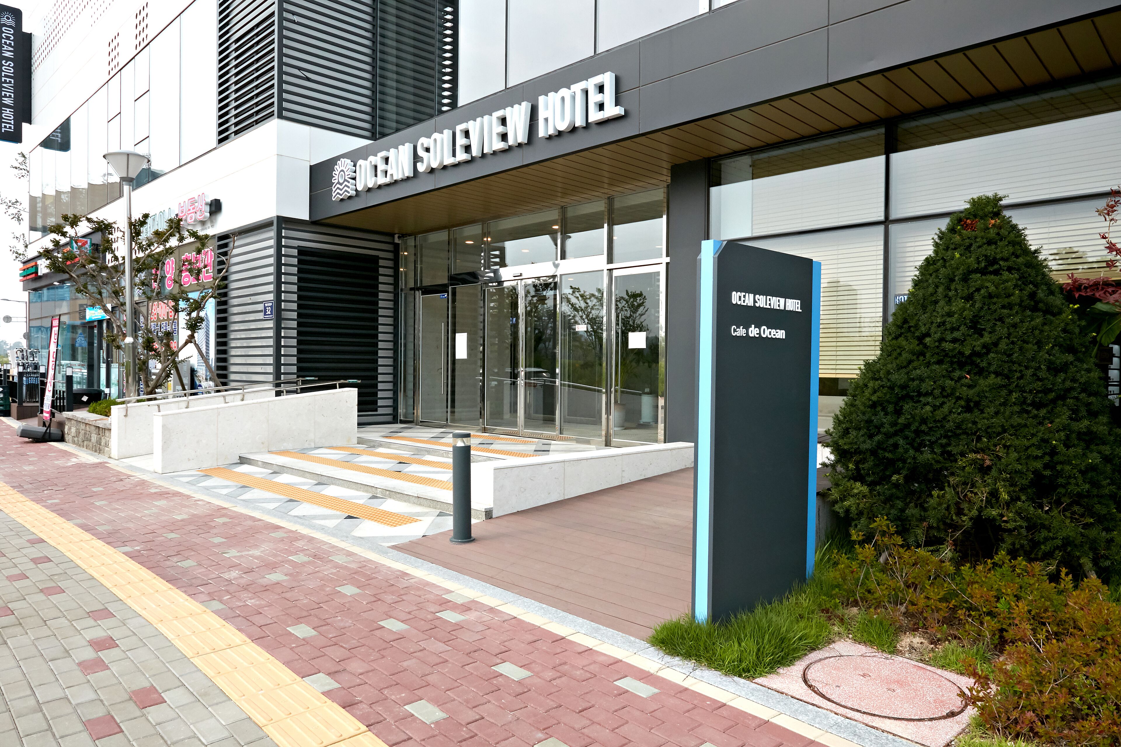 Hotel Ocean Soleview, con fachada moderna, grandes ventanales y entrada visible.