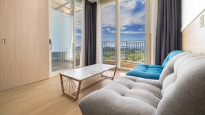Un saló modern amb un sofà, una taula i vista a un balcó amb barana.