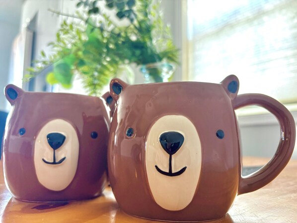 Two ceramic mugs with bear faces on a wooden surface. - Mountain View Escape - Top Floor (Canmore)
