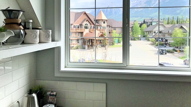 Eine Küche mit großem Fenster mit Blick auf ein Gebirge und eine Stadt.