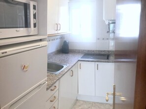 Fridge, microwave, coffee/tea maker, cookware/dishes/utensils